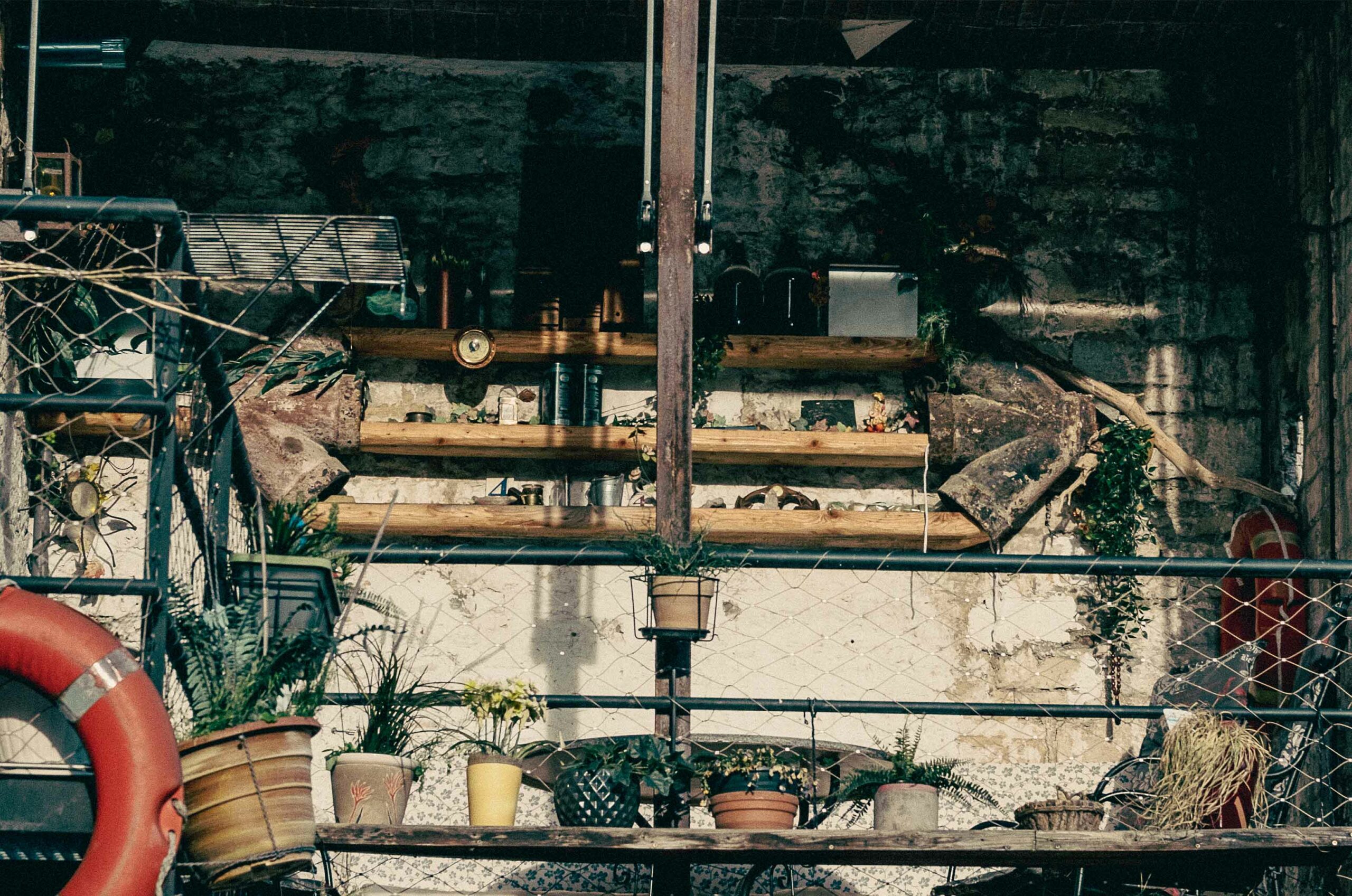 Picture of a balcony whit a lot of flower and wood stuff.