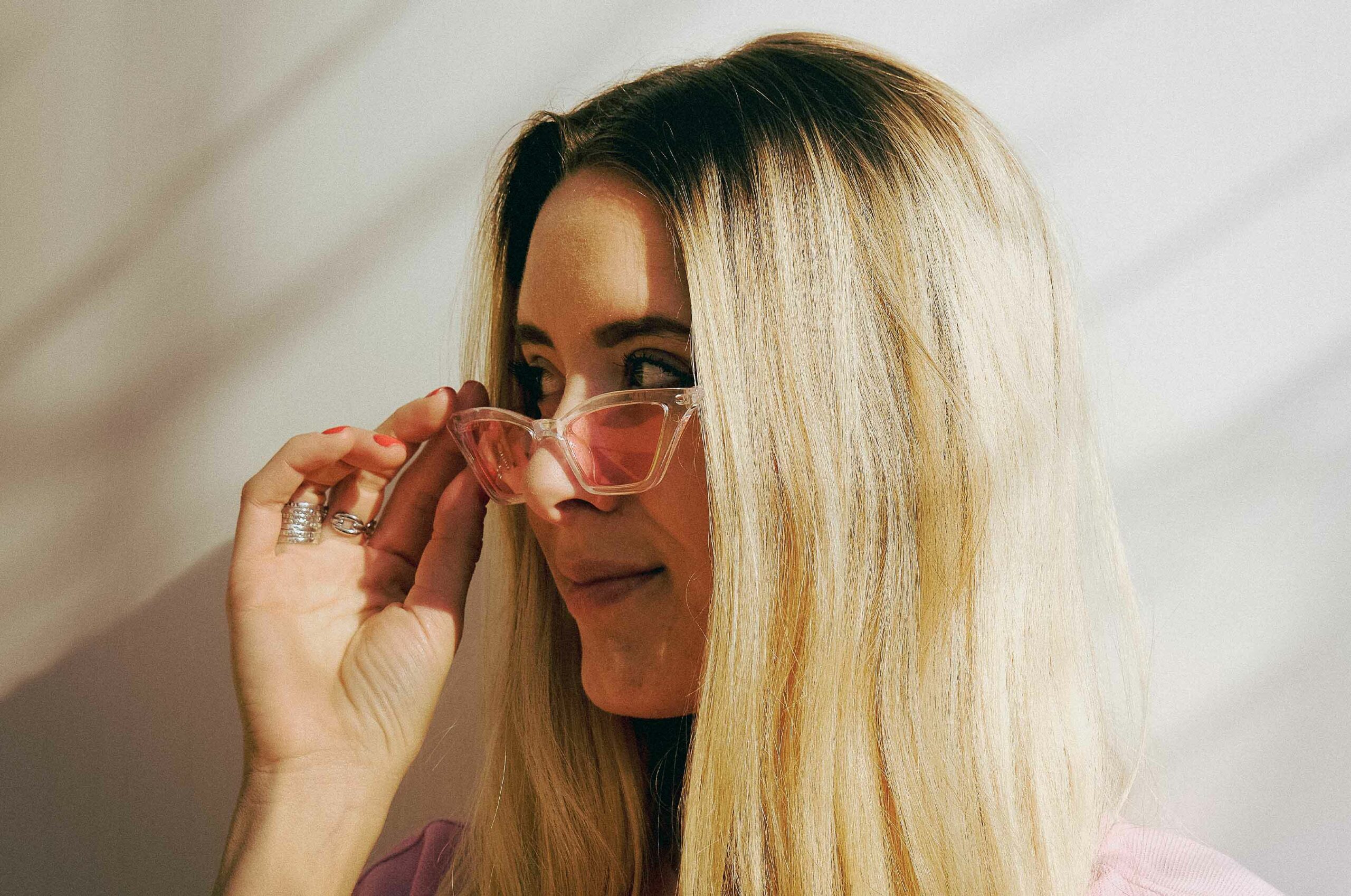 Portrait of a woman with blond hair and pink glasses looking side ways during sunlight.
Take in Lyon , France
